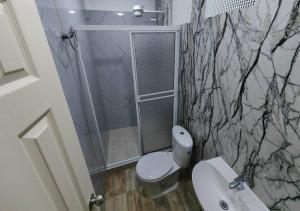 a bathroom with a toilet and a shower at Apartahotel Arcoiris Salento in Salento