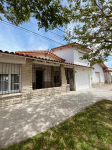 a house with a driveway in front of it at Casa Miriam - Casa En Miramar Para 4 PAX Con Cochera - Hola Sur in Miramar
