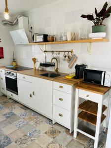 una cucina con mobili bianchi e un lavandino di Casa Carminho a Nazaré