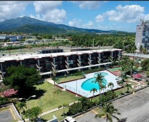 um grande edifício com uma piscina em frente em Relaxing Studio Near El Yunque With Pool View em Luquillo