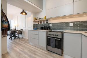 a kitchen with white cabinets and a stove top oven at Urban Retreat in the heart of Green Point in Cape Town