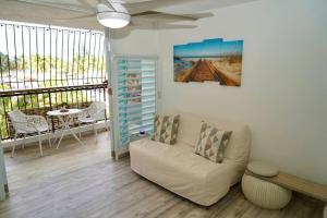 uma sala de estar com um sofá e uma mesa em Relaxing Studio Near El Yunque With Pool View em Luquillo