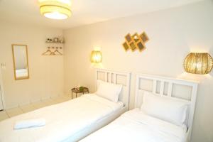 two beds sitting next to each other in a room at Villa Petite Fleur proche Paris CDG Disney Astérix et Parc des Expos in Villeparisis