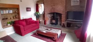a living room with a red couch and a fireplace at Hill House in Banbury