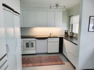 a kitchen with white cabinets and a sink at Tilava uudistettu perheasunto in Rovaniemi