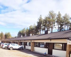 a building with cars parked in a parking lot at Tilava uudistettu perheasunto in Rovaniemi