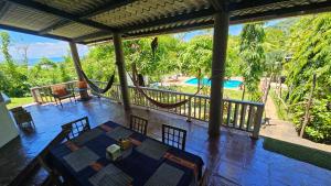 a room with a table and chairs on a porch at Jaco Mizata Beach and River in Las Piedras