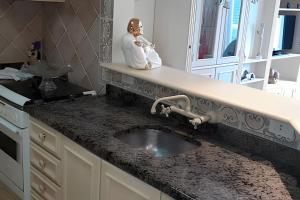 a kitchen sink with a statue of a man holding a baby at Centro, Rua Coberta, perto de tudo! in Gramado +15 photos