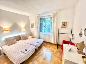 una camera da letto con due letti e una finestra di Chambres d'hôtes Avignon ad Avignone