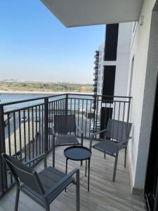 Un balcón con sillas y una mesa en un edificio. en F1 - Daisy Hill 1BR Waters Edge Canal View Yas island - Theme Parks, en Abu Dabi