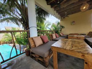 a porch with a wooden table and a bench at Zoah Surf Hotel, El Paredón in El Paredón Buena Vista