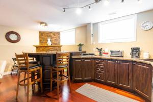 a kitchen with a counter and a table with stools at Nancy by the Bay Wasaga Beach in Wasaga Beach