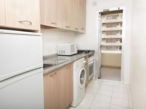 a kitchen with a washer and dryer and a refrigerator at Apartamentos Turmalina Unitursa in Calpe