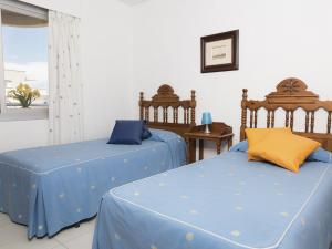 2 camas con sábanas azules en una habitación con ventana en Apartamentos Turmalina Unitursa, en Calpe