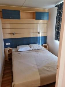 a bedroom with a bed with two pillows on it at Mobil home à Boofzheim - EUROPA PARK et RULANTICA in Boofzheim +31 photos
