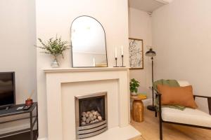 ein Wohnzimmer mit einem Kamin und einem Spiegel in der Unterkunft Idyllic 1 Bed Apt in Beautiful Village of Chester in Hough Green