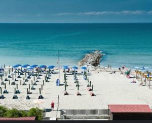 una playa con sombrillas y gente en la playa en Le Conchiglie, en Marinella di Sarzana