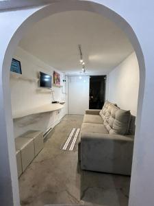 a living room with a couch sitting under an archway at Apartamento no Centro de Londrina in Londrina