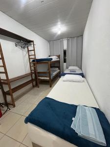 a room with two beds and a chair in it at Apartamento no Centro de Londrina in Londrina
