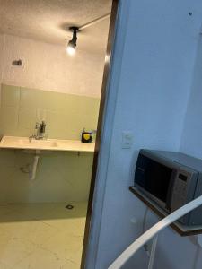 a bathroom with a sink and a microwave at Apartamento no Centro de Londrina in Londrina +30 photos