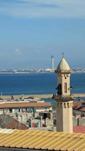 a building with a clock tower next to the water at Appartement au cœur d'Alger in Kasbah +3 photos