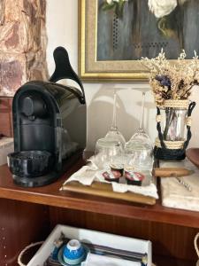 a table with glasses and a coffee maker on it at Casa bucólica para casais apaixonados in Flores da Cunha