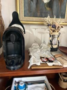 a table with a coffee maker and glasses on it at Casa bucólica para casais apaixonados in Flores da Cunha +13 photos