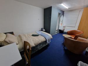 a hotel room with a bed and a chair at Room near East Midland Airport 6 in Kegworth