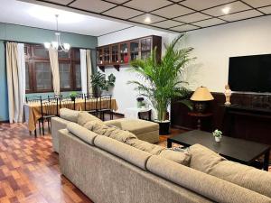 Una sala de estar con un sofá y un comedor. en 5BR House BTSNana Nanaplaza City center MBK Center world, en Bangkok