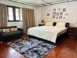 Un dormitorio con una cama grande y un sofá. en 5BR House BTSNana Nanaplaza City center MBK Center world, en Bangkok