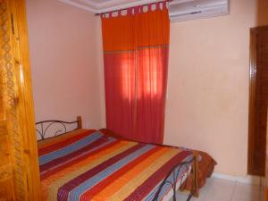 ein Schlafzimmer mit einem Bett und einem roten Vorhang in der Unterkunft RYAD Pierre in Marrakesch