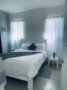 ein Schlafzimmer mit einem weißen Bett mit weißem Himmelbett in der Unterkunft A Caribbean-style rebirth, 2 minutes from the beach in La Romana