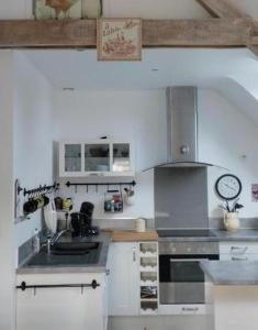 a kitchen with a sink and a stove top oven at La grange du Manemeur in Quiberon