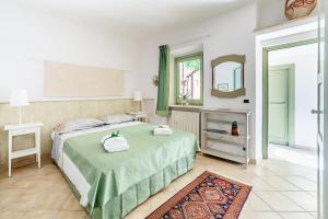 a bedroom with a green bed and a mirror at Domus Colonnato su Villa d'Este in Tivoli