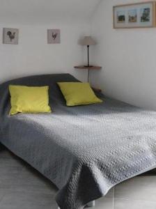 a bed with two yellow pillows in a bedroom at La grange du Manemeur in Quiberon