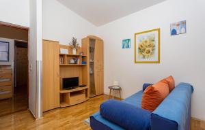 a living room with a blue couch and a television at 1 Bedroom Lovely Apartment In Jurandvor in Jurandvor