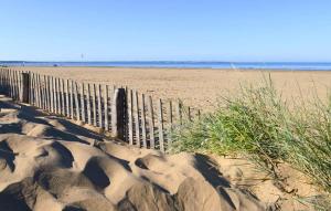a fence on a sandy beach next to the ocean at Gorgeous Home In Saint-Brevin-Les-Pins in Saint-Brevin-les-Pins