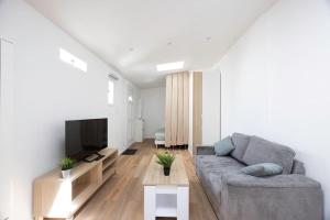 a living room with a couch and a flat screen tv at Studio Cosy Terrasse au Calme CDG Disney in Chelles
