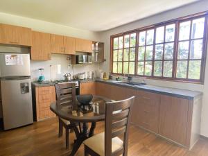 a kitchen with a table and chairs and a refrigerator at Casa de campo in Oxapampa