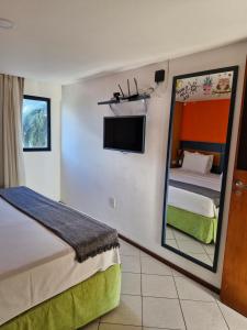 a hotel room with a bed and a mirror at Hotel Natal Plaza com piscina, academia, 100m da praia de Ponta Neg in Natal +56 photos