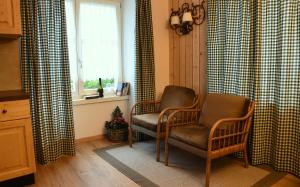 a living room with two chairs and a window at Ca' del Pettirosso in Baselga di Pinè +43 photos