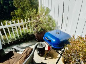a blue grill sitting on a patio next to a fence at Happy Hedgehog River Views Hot Tub Private in Ahwahnee