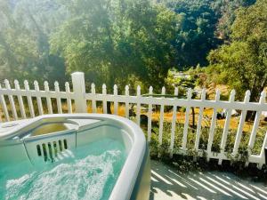 a bath tub sitting next to a white fence at Happy Hedgehog River Views Hot Tub Private in Ahwahnee