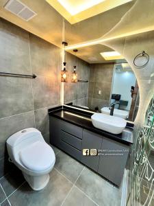 a bathroom with a toilet and a sink and a mirror at Lujoso apartamento en la ciudad de Neiva-Huila-T in Neiva