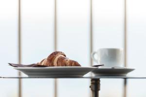 a plate of bread and a cup of coffee on a table at Best Western Hotel Santa Caterina in Acireale