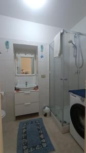 a white bathroom with a shower and a sink at Room34Trani in Trani