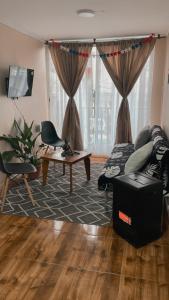 a living room with a couch and a table at Departamento Dichato hasta 7 personas frente a la playa in Dichato