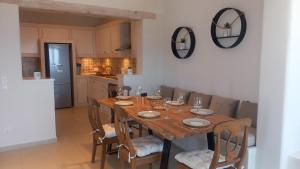 a dining room table with chairs and a kitchen at Sails in Agia Eleousa