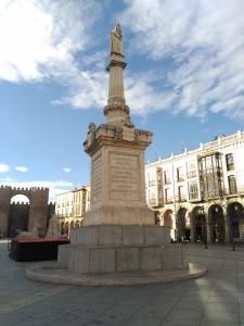 una estatua en una plaza delante de un edificio en Hostal Doña Juana, en Ávila