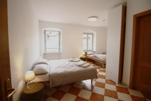 a bedroom with a bed and a checkered floor at NIDO SUL CERMIS Affittacamere in Varena +16 photos